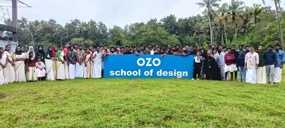 OZO students in traditional wear with the school banner on the lawn