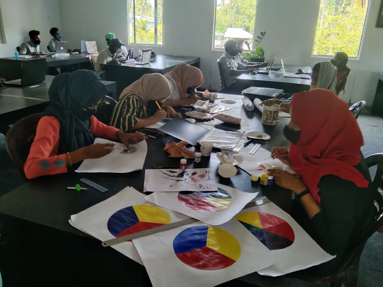 Students painting colour wheels in class