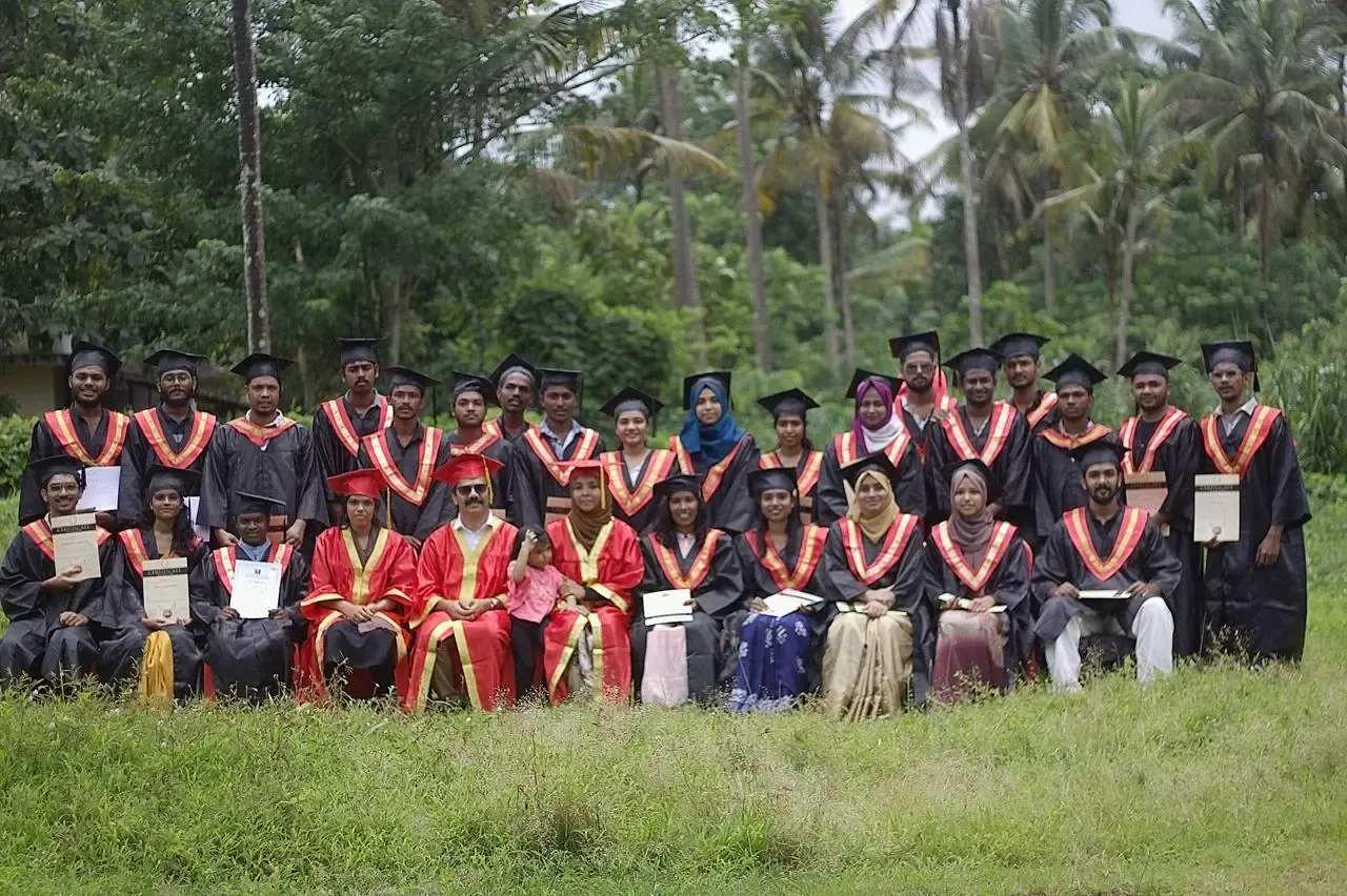 OZO graduates in caps and gowns holding their certificates