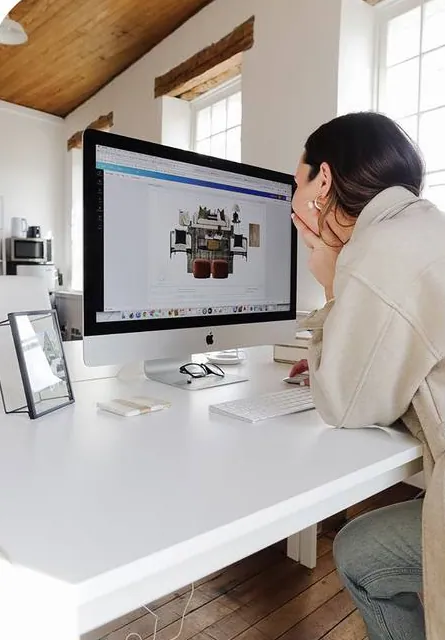 A designer reviewing a 3D render at her desk